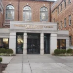 Brick facade of building with a glass door entrance